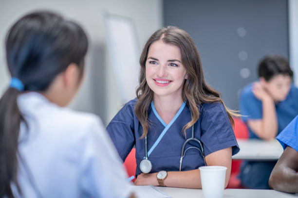 Medical students studying together A diverse group of students sit beside each other in the classroom and discuss their course material. medical schools stock pictures, royalty-free photos & images