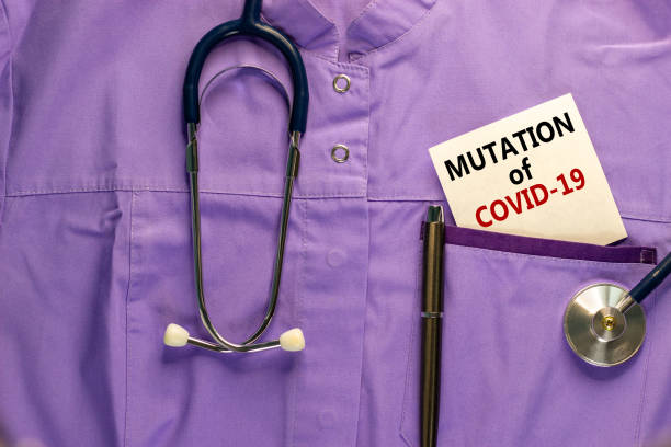 medizinische uniform, weiße karte mit wörtern mutation von covid-19, metallstift und stethoskop. medizinisches und covid-19 pandemiekonzept. - coronavirus mutation stock-fotos und bilder