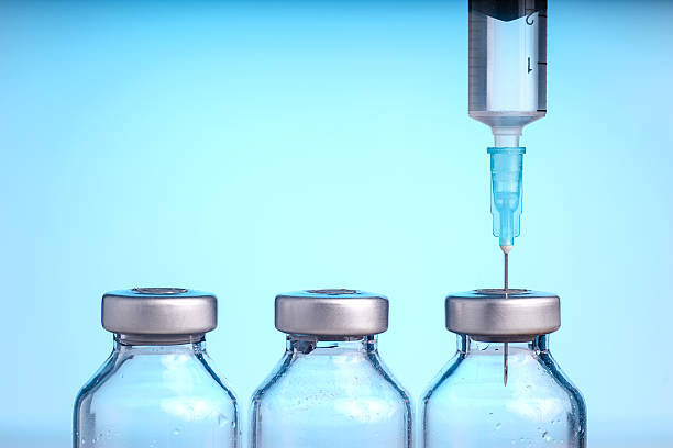 Medical vials and Syringe Medical vials and Syringe, Isolated on Blue background dose stock pictures, royalty-free photos & images
