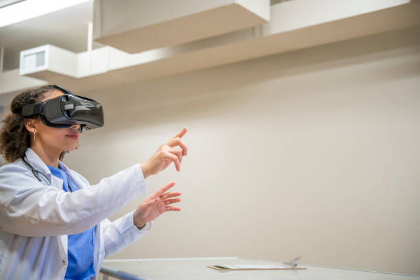 Medical VR Female medical professional using a virtual reality headset in a clinic to explore a medical case for educational purposes. virtual reality point of view stock pictures, royalty-free photos & images