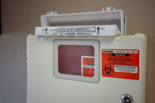 Medical Waste needle disposal Bin on Wall of Doctor Office stock photo