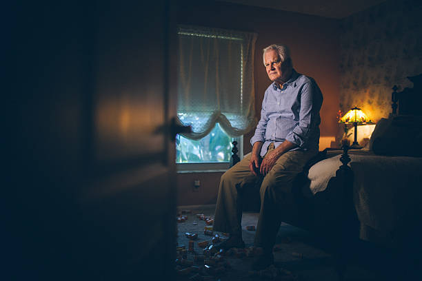 Medicine addiction Depressed senior man alone sitting on bed edge with dozens of pill container at his feet depression land feature stock pictures, royalty-free photos & images