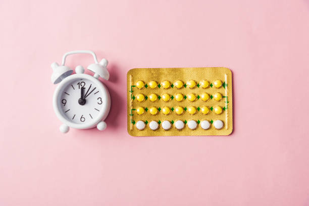 medicine birth control, alarm clock and contraceptive pills World sexual health or Aids day, Top view flat lay medicine birth control, alarm clock and contraceptive pills, studio shot isolated on a pink background, Safe sex and reproductive health concept birth control pill stock pictures, royalty-free photos & images