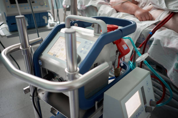 Medicine. Extracorporeal membrane oxygenation. Working ecmo machine in intensive care department. Closeup oxygenator of ECMO. Seriously ill patient on background. stock photo