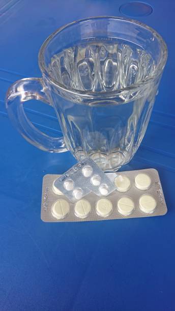 Medicine pills photo of Medicine pills  and a glass of water on the table abortion pill stock pictures, royalty-free photos & images