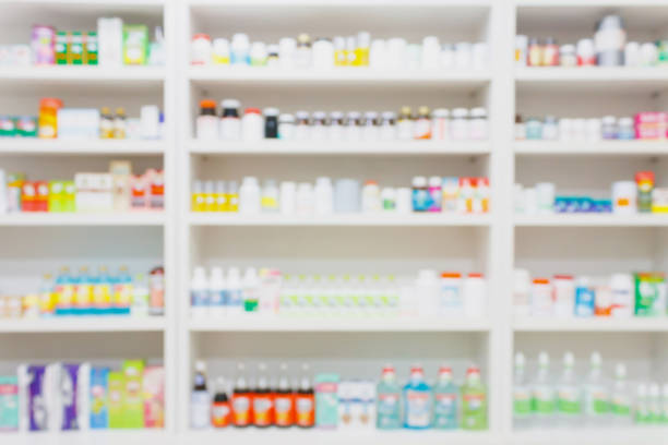 лекарства, расположенные на полках в аптеке размыты фон - pharmacy стоковые фото и изображения