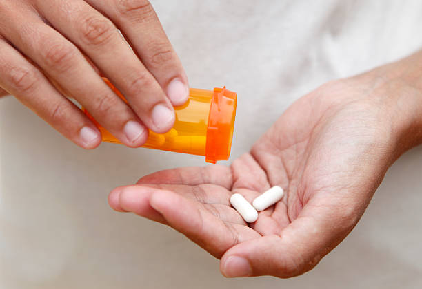 medicamentos en mano - antibiótico fotografías e imágenes de stock