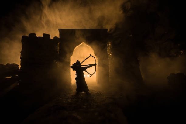 Medieval battle scene. Silhouettes of figures as separate objects, fight between warriors at night. Creative artwork decoration. Foggy background. stock photo