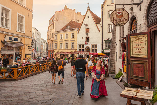Medieval city of Tallinn Tallinn, Estonia - July 24, 2016: A woman greets tourists outside a restaurant in one of the many busy streets in Tallinn's old town. estonia stock pictures, royalty-free photos & images