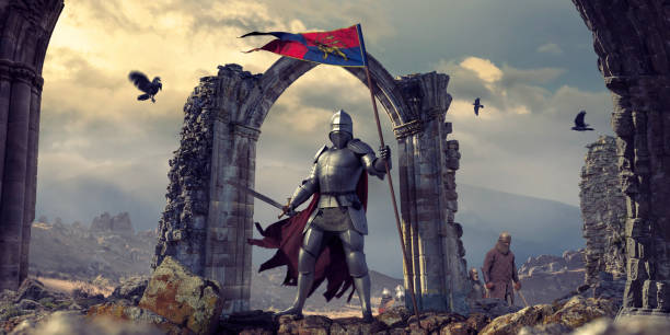 Medieval Knight In Armour With Flag and Sword Near Ruins A medieval knight wearing full armour, chainmail and cape, standing heroically, holding a banner flag with sword drawn. The knight stands on rocks in front of an archway of ruins. Other infantry are in the background, along with ravens flying nearby in the dramatic evening sky. warriors stock pictures, royalty-free photos & images