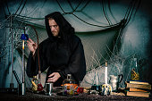 The alchemist works in the laboratory. A medieval scientist conducts an experiment to obtain a philosophical stone. Halloween