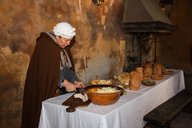 Medieval Woman in medieval clothes preparing lunch on historical reenactment in Gorizia, Italy. stock photo