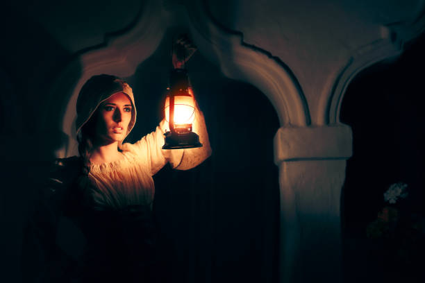 Medieval Woman with Vintage Lantern Outside at Night Cosplay girl in Halloween costume holding a lamp chiaroscuro stock pictures, royalty-free photos & images