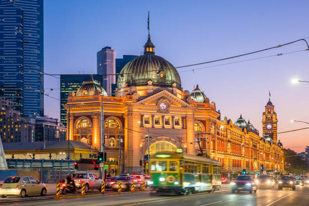 Melbourne Flinders Street Train Station in Australia Melbourne Flinders Street Train Station with moving tram in Australia at sunset melbourne street stock pictures, royalty-free photos & images