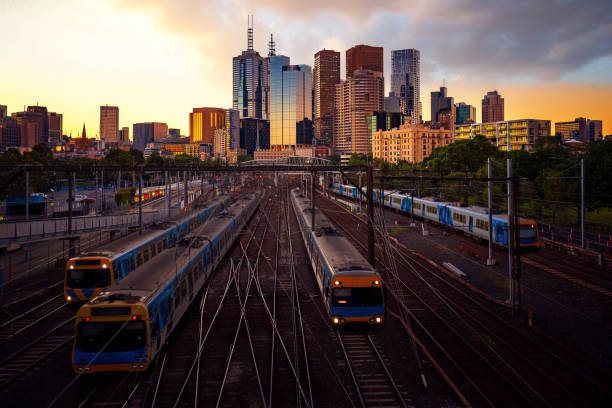 Melbourne train staation with Melbourne city background Melbourne train staation with Melbourne city background in sunset, Australia, this immage can use for Melbourne travel and transportation. melbourne street stock pictures, royalty-free photos & images