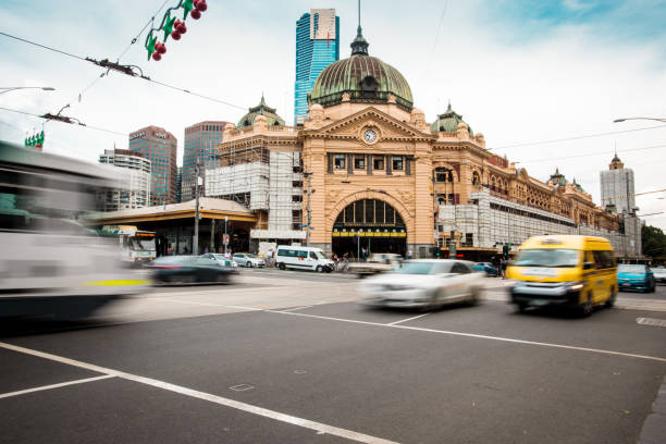 Melbourne train station with traffic in motion blur. Melbourne, Australia - 30-november-2017: train station with traffic in motion blur. melbourne street stock pictures, royalty-free photos & images
