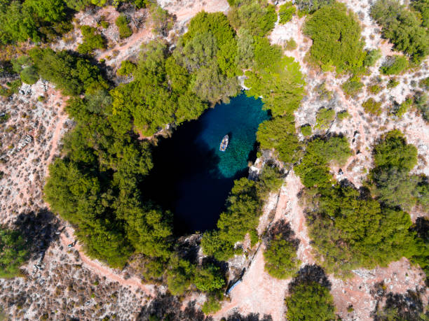 Melissani Cave Cephalonia (Kefalonia) viewed from above with tourists entering the cave by boat stock photo