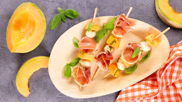 melon salad with prosciutto ham and mozzarella stock photo