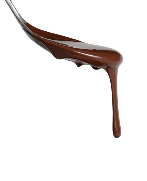 Melted chocolate dipping from a spoon Chocolate dripping from spoon dessert topping stock pictures, royalty-free photos & images