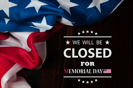 Memorial Day Background Design. American flag on a background of wooden table with a message. We will be Closed for Memorial Day.