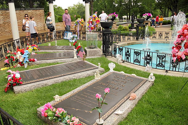 Memorial Garden at Graceland Memphis with Elvis Presley's Grave "Memphis, TN, United States - June 18, 2011: Memorial Garden at Graceland Memphis with Elvis Presley's grave, father, Vernon Elvis Presley's grave, mother, Gladys Love Smith Presley's grave and grandmother, Winnie May Presley's grave, while tourists travel through to pay respects and drop momento's on the graves." graceland stock pictures, royalty-free photos & images