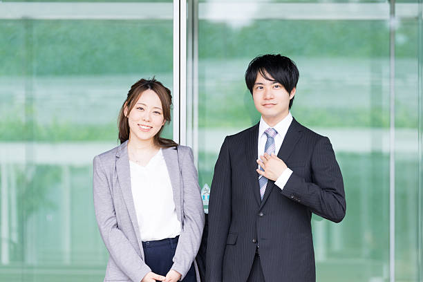 自動ドアの前に立つ男女 - 若者　日本人 ストックフォトと画像