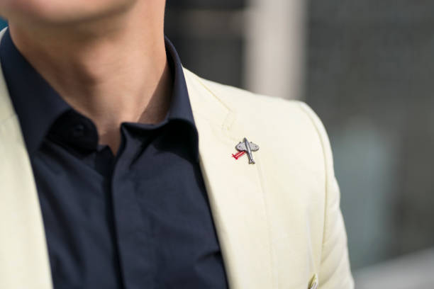 Men Brooch Close-up of an unrecognizable man in a shirt and tuxedo with an airplane brooch. lapel pins stock pictures, royalty-free photos & images