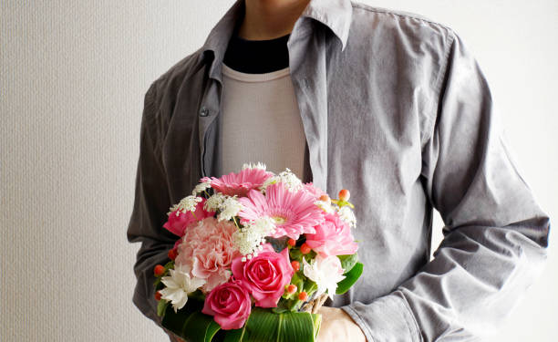 花を手渡す男性 - 花束 ストックフォトと画像