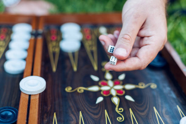 Men playing backgammon Close up man hand holding backgammon dices and playing backgammon at outside backgammon stock pictures, royalty-free photos & images