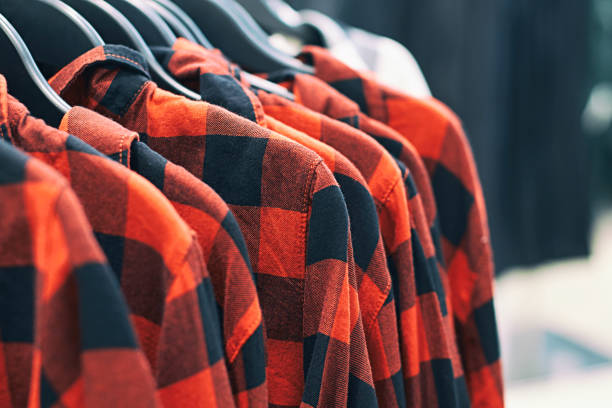 Men red plaid shirt on hangers in a retail clothes store. Fashion trend concept. Interior of clothes store. plaid shirt stock pictures, royalty-free photos & images