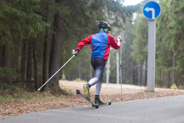 Men ride roller skis in the autumn Park. stock photo