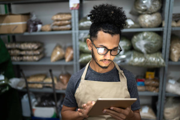 hombres que usan tableta digital en el trastero de una tienda de productos naturales - negocio y alimentos fotografías e imágenes de stock