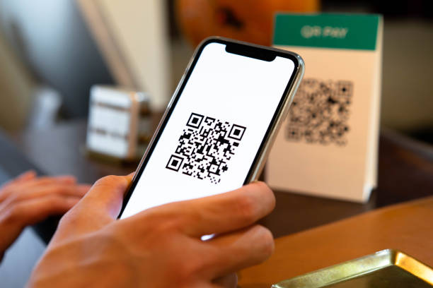 Men who use QR codes to make contactless payments using their smartphones stock photo