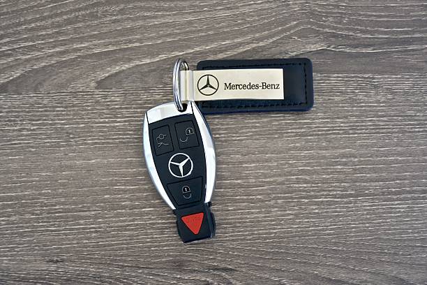 Mercedes-Benz key fob on wood surface Odenton, USA - April 10, 2016: A Mercedes-Benz key fob laying on a wood surface. Mercedes-Benz is a luxury car manufacturer and dealer. mercedes benz stock pictures, royalty-free photos & images
