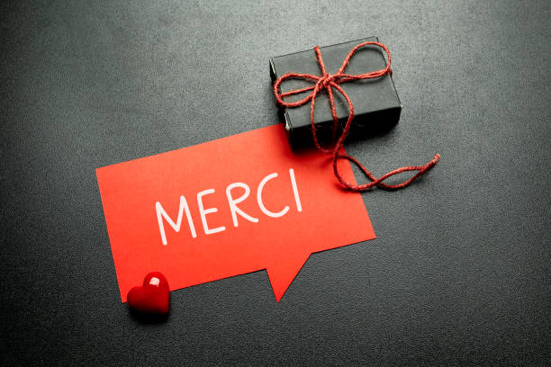merci (thank you in french language) written on speech bubble stock photo