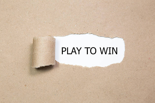 PLAY TO WIN message written under torn paper. stock photo