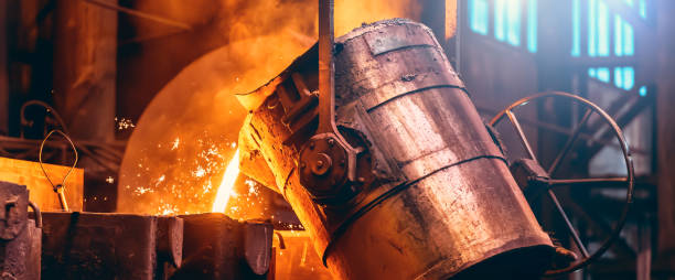 Metal cast process, long banner image. Molten liquid iron pouring from ladle container into mold stock photo
