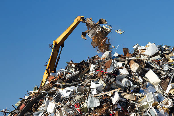 Metal Recycling Junkyard, Blue Sky, With Crane Throwing Trash stock photo