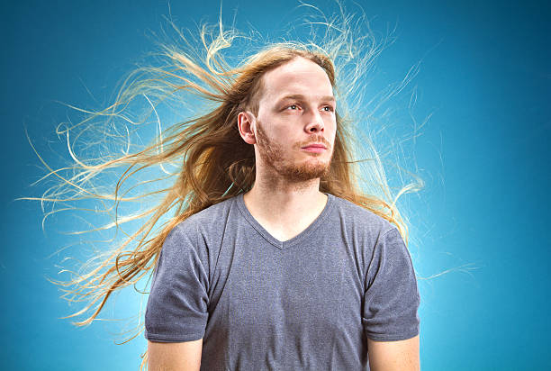 Metalhead dude with long hair blowing in the wind Serious man with a long blond hair long hair stock pictures, royalty-free photos & images