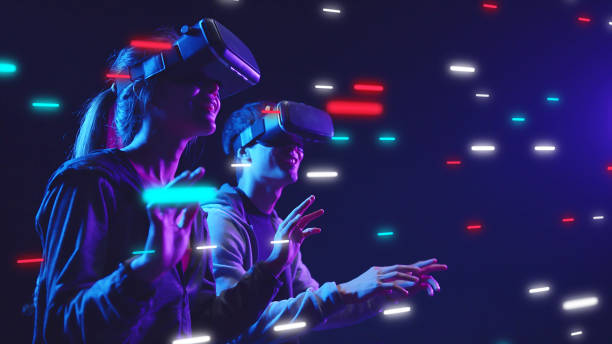 Metaverse VR virtual reality game playing, man and woman play metaverse virtual digital technology game control with VR goggle stock photo