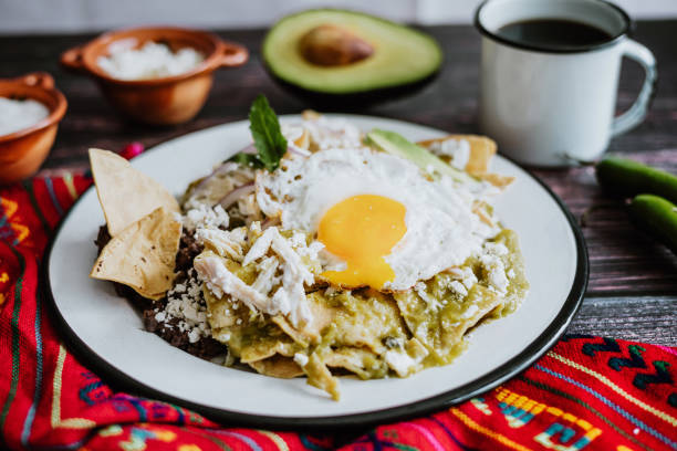 mexican chilaquiles with fried egg, chicken and spicy green sauce traditional breakfast in Mexico stock photo