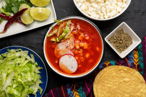 Mexican food. Red pozole with chicken on dark background stock photo