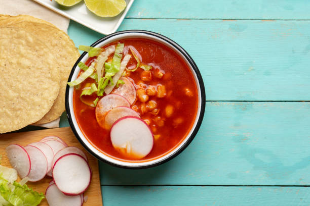 Mexican food. Red pozole with chicken on turquoise background stock photo