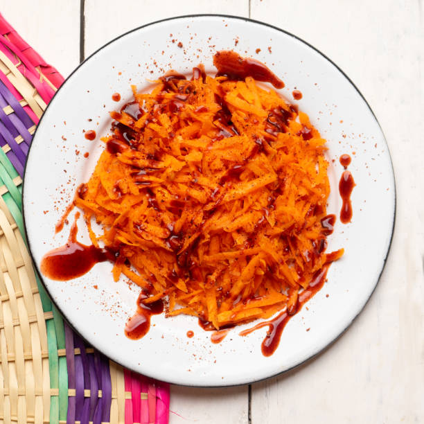 zanahoria rizada mexicana con salsa chamoy y chile en polvo sobre fondo blanco - fruta con chamoy fotografías e imágenes de stock