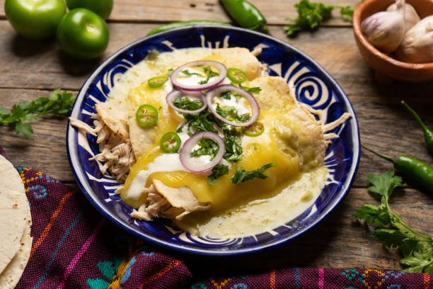 Mexican green enchiladas with chicken and melted cheese stock photo