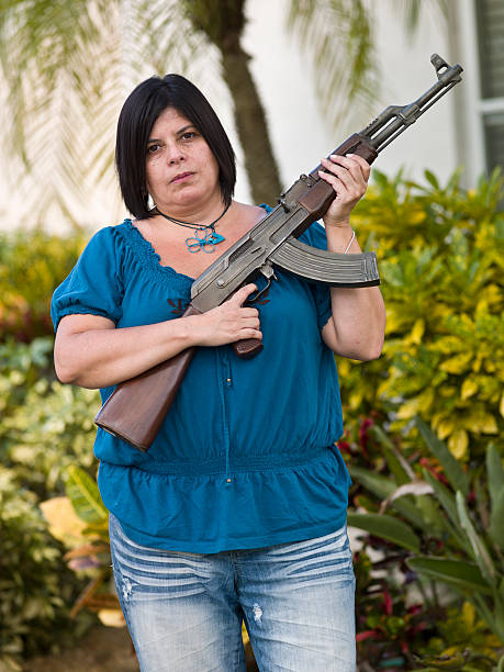Mexican Housewife holding an assault Rifle Mexican housewife posing outside her house holding an AK 47 Assault Rifle puerto rican women stock pictures, royalty-free photos & images