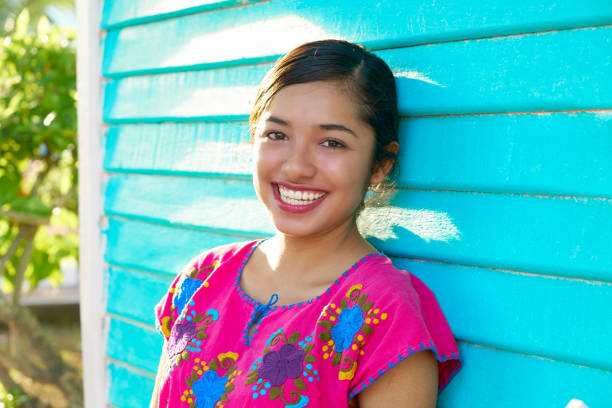 Mexican latin woman with mayan dress Mexican latin woman with mayan dress smiling in turquoise wall mexican woman stock pictures, royalty-free photos & images