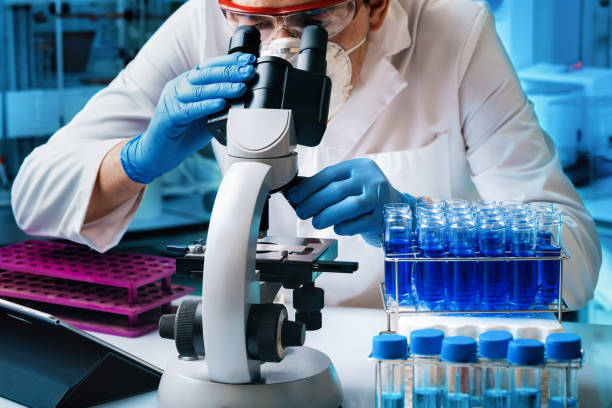 Microbiologist working with biological samples in microscope of the microbiology lab Scientist researcher analyzing molecular samples to microscope of laboratory. Microbiologist working with biological samples in microscope of the microbiology lab monkeypox vaccine stock pictures, royalty-free photos & images