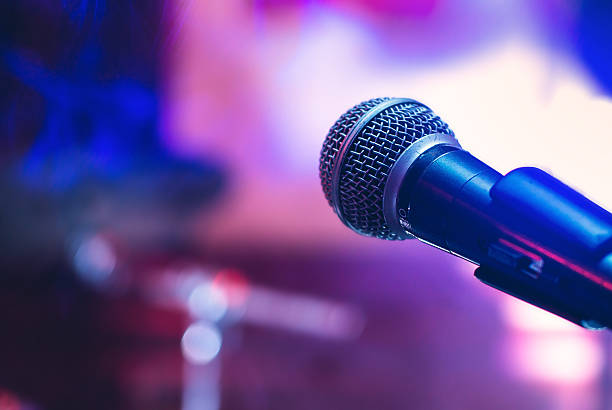 Microphone at concert Microphone on the stage on violet background. singer stock pictures, royalty-free photos & images