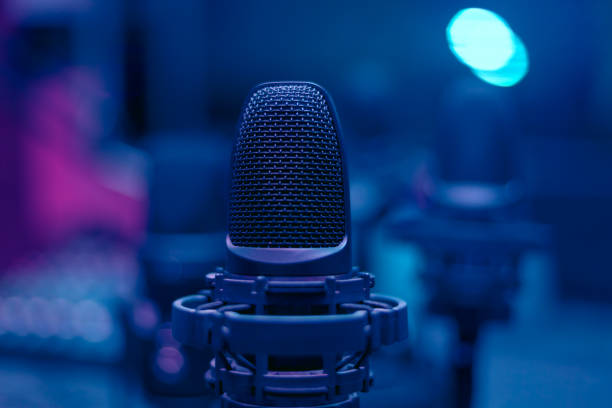 Microphone in blue room Microphone in blue room . Low light in broadcasting studio podcasting stock pictures, royalty-free photos & images